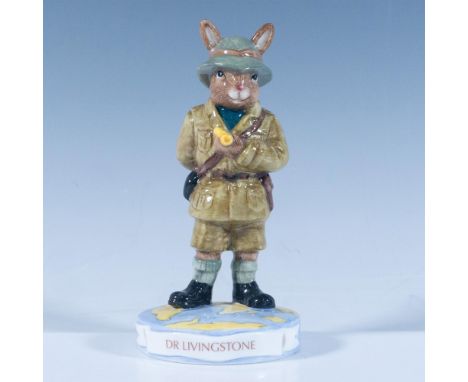 A figure of the pioneering Scottish explorer, dressed for an adventure, holding a compass and standing over a world map base.