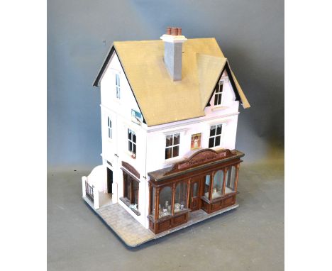 A Scratch Built Dolls' House modelled as Busbridge Stores with shop front complete with a large quantity of dolls' house furn