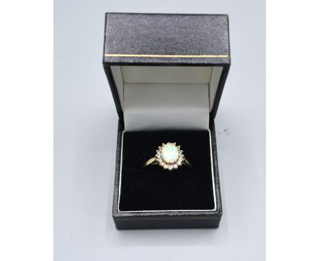 A 9ct. Gold Dress Ring set oval opal type stone surrounded by cubic zirconia claw set 