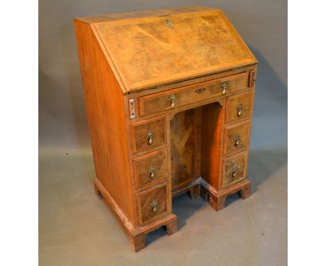 A Circa 1920's Queen Anne Style Walnut Bureau, the fall front enclosing a fitted interior above seven drawers with brass drop