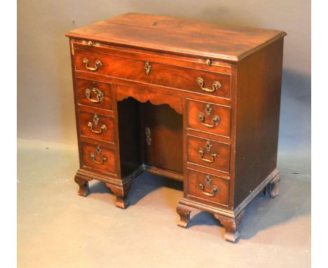 A George III Mahogany Kneehole Desk, the moulded top above a brushing slide and seven drawers with central kneehole cupboard 