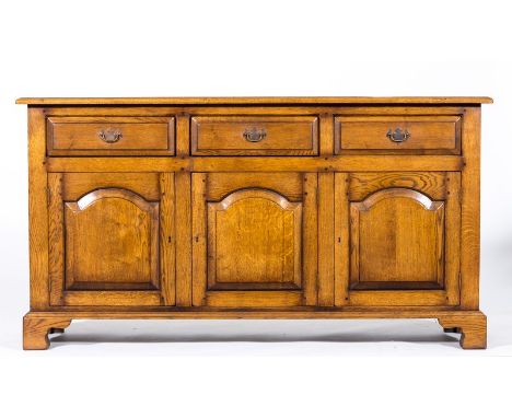 Oak dresser base, by Haselbech Oak, fitted with three drawers, over three arched fielded panelled doors, bracket feet, width 