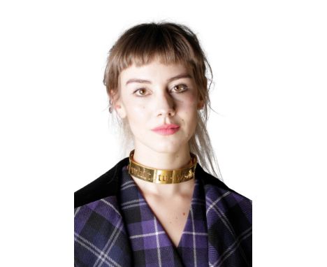 VIVIENNE WESTWOOD: YELLOW METAL CHOKER, with cut out design spelling 'Tu-whit-tu-who' and decorated with the trademark ringed