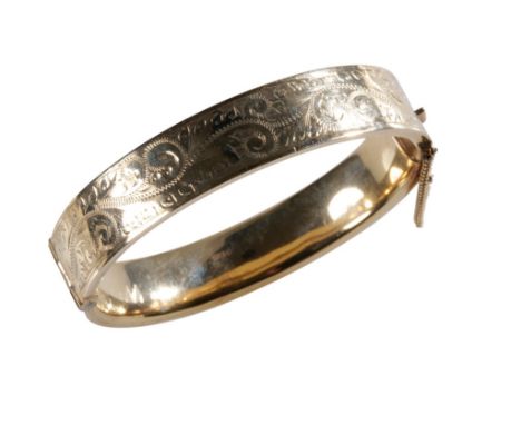 9CT YELLOW GOLD BANGLE, half engraved with scrolls, concealed clasp with safety chain, 17.50grams