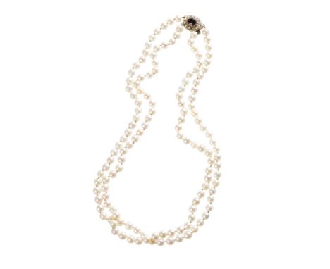 DOUBLE STRAND CULTURED PEARL NECKLACE, each pearl knotted, with a yellow gold clasp set with a single garnet and seed pearls,