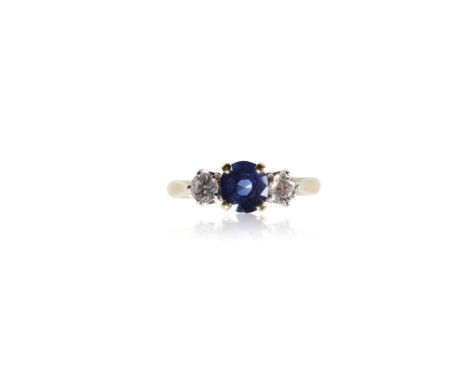 THREE STONE SAPPHIRE AND DIAMOND RING, the centre round-cut sapphire, approximately .85ct, flanked either side by a round-cut