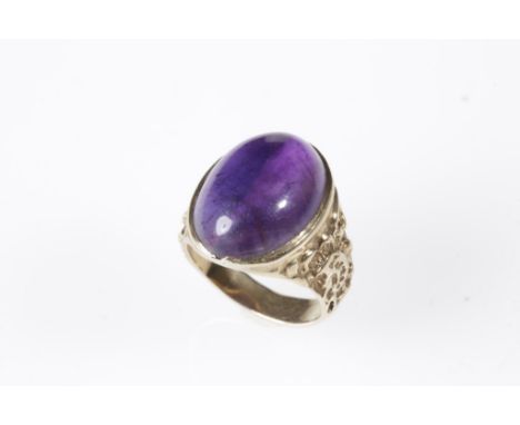 GENTLEMAN'S CABOCHON "AMETHYST" RING, the "amethyst" collet-set on an 18ct yellow gold shank with embossed shoulders. Ring si