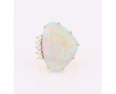 An 18ct yellow gold opal and diamond dress ring, set with a curved triangular opal cabochon, measuring approx. 23x17mm, with 