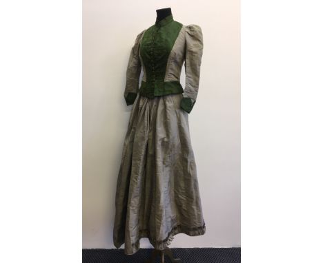 A 19th century two piece ladies outfit in green and grey with button up top.