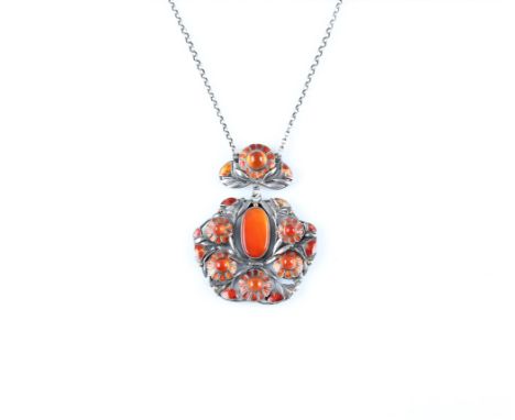 An Art Nouveau style orange enamel and orange stone pendant, of floral design.