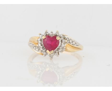 A hallmarked 9ct yellow gold ruby and diamond ring, set centrally with a heart cut ruby (possibly synthetic), surrounded by d