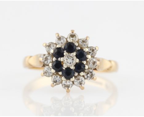 A 9ct yellow gold sapphire and diamond tiered cluster ring, claw set with a central round brilliant cut diamond, measuring ap