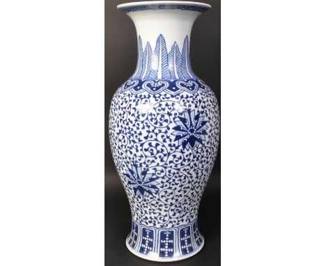 A large vintage 20th century Chinese blue and white vase of baluster form. The vase having florals and arabesque to body with