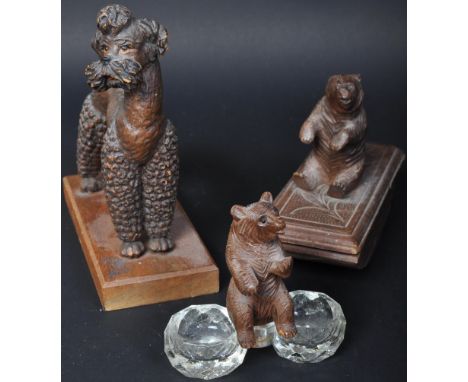 An assortment of 20th century black forest wooden carvings to include a blotter with a figure of a bear on top, a glass table