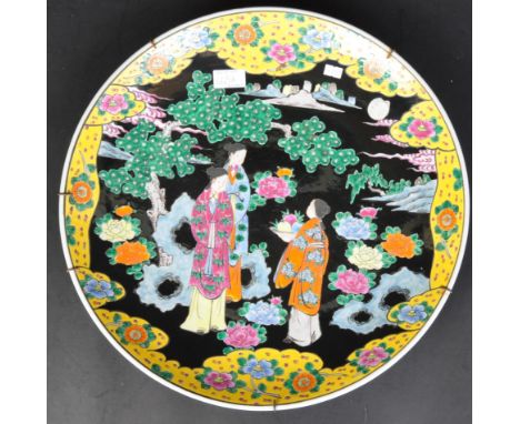 Vintage 20th Century Japanese manner of Meiji period Famille noir decorated charger plate, depicting figures offering a bowl 