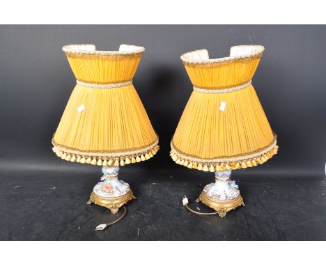 A pair of 20th century German Sitzendorf porcelain lamp bases, each having a white ground and being painted with gilt details