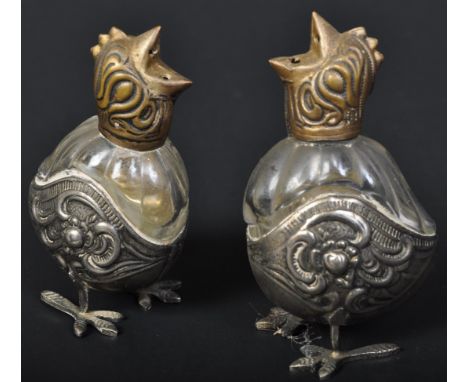 A pair of early 20th century silver plated and brass cockerel condiment shakers / cruet set. Each having glass bodies with re