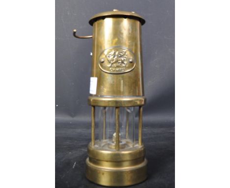 A vintage 20th century brass Welsh miner's lamp with hanging hook. The lamp having a frontal plaque with Welsh flag. Measurin