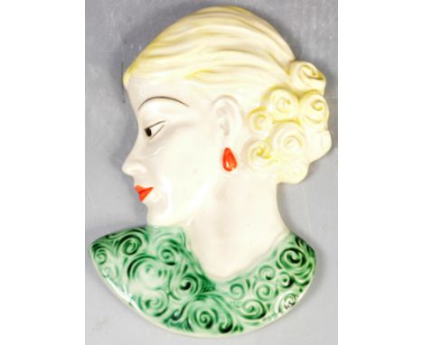 A vintage early 20th Century 1930s Art Deco ceramic hand polychrome decorated wall plaque of a blonde hair girl wearing a pai