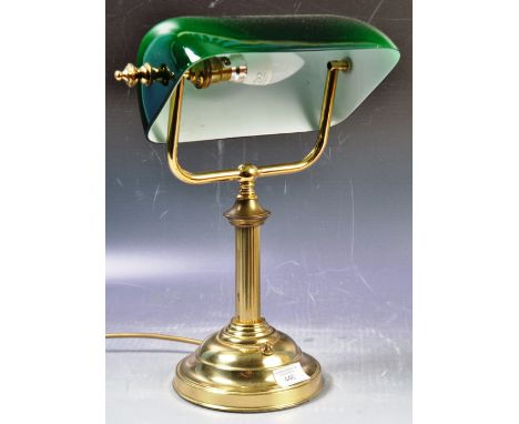 A vintage 20th Century English bankers desk / table lamp light of brass construction having an adjustable green glass shade s