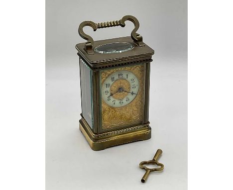 A French circa 1900 brass carriage clock with elborate floral engraved front plate, Arabic numerals to the chapter ring signe