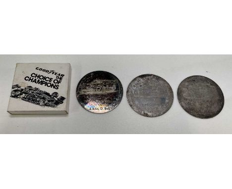 A group of motor racing and car memorabilia including two AA badges and a quantity of 1970s circular silvered metal plaques, 