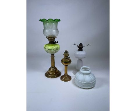 A Victorian brass oil lamp with green tinted shade and Art Nouveau inspired reservoir, an opaque glass lamp base with shade a