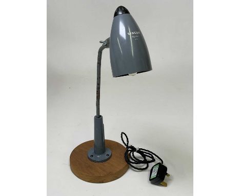 A mid 20th century Singer sewing adjustable industrial lamp mounted on a circular oak base, height 44cm, recent rewire and PA