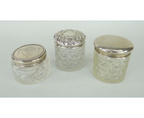 THREE VARIOUS SILVER LIDDED VINTAGE GLASS DRESSING TABLE JARS each with clear hallmarks, one plain, two decorative