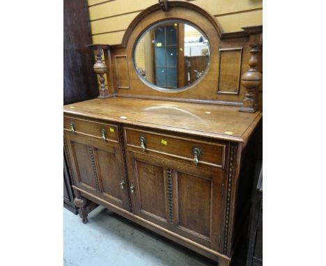 VINTAGE OAK MIRROR BACKED SIDEBOARD on raised feet with two drawers above two cupboards, 122cms wide