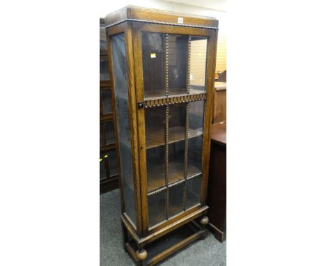 VINTAGE DARK OAK SINGLE GLAZED DOOR CABINET on a raised bobbin and stretcher base