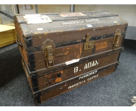 A VINTAGE DOME TOP WOODEN BANDED CANVAS STEAMER TRUNK with travel stickers for the ship SS RHODESIA CASTLE