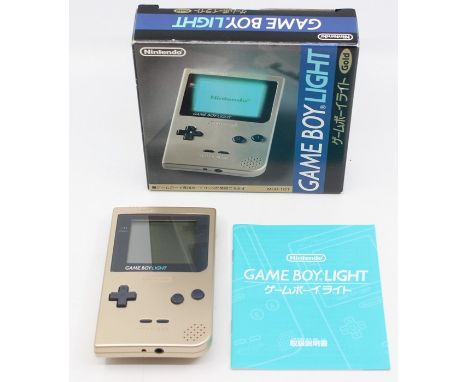 Nintendo: A boxed Gameboy Light Console, Gold, MGB-101, with instructions. Slight wear to battery cover.