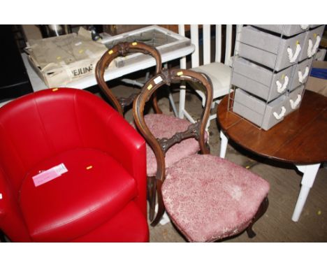 A red leather tub chair and matching pouffe