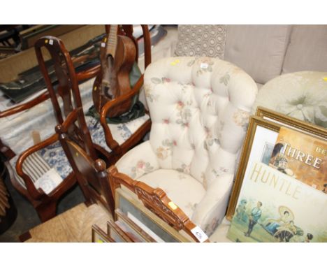 A floral upholstered and button back nursing chair raised on squat cabriole supports