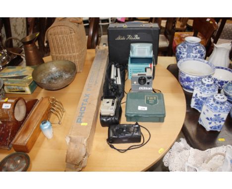 A camera tripod; cameras; polaroid camera; slide box etc