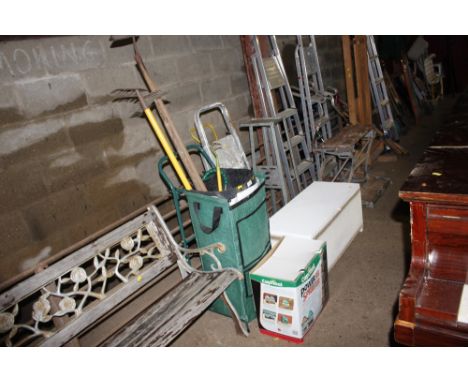 A garden two wheel trolley and contents of long handled gardening tools