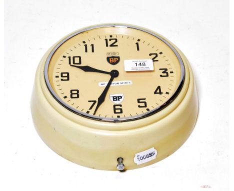 A 1950's BP Motorspirit Metamec Electric Wall Clock, with cream bakelite case, salmon colour face with black lettering and a 