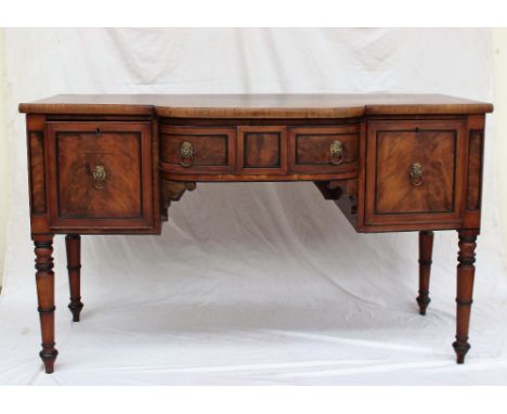 An early 19th century mahogany sideboard with a shaped front, above three drawers on four ring turned legs, 156cm wide x 70cm