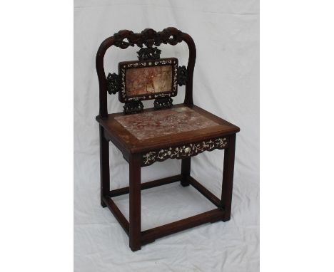 A Chinese hardwood and marble inset chair the back carved with scrolls, leaves and fruit, inset with mother of pearl, the sea