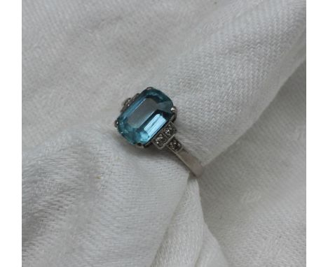 An aquamarine and diamond dress ring, the rectangular faceted aquamarine measuring 10mm x 7mm, with diamond set shoulders to 