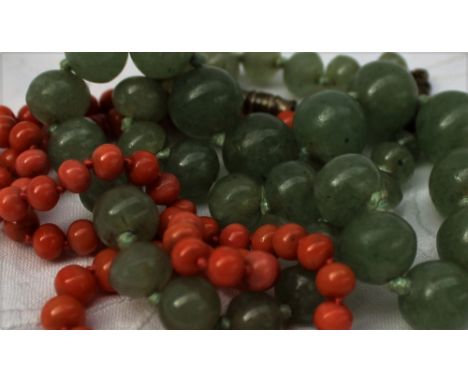 A green jade bead necklace, on a knotted cotton thread with a twist clasp, together with a coral bead necklace CONDITION REPO