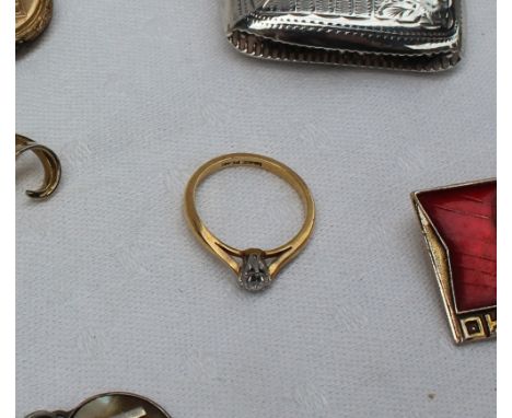 A solitaire diamond ring, the round old cut diamond, approximately 0.20 of a carat to a white metal claw setting and yellow m