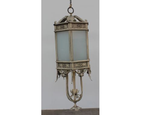 A cream coloured hanging lantern and arm, with six glazed panels, and leaf mounts, 95cm high  