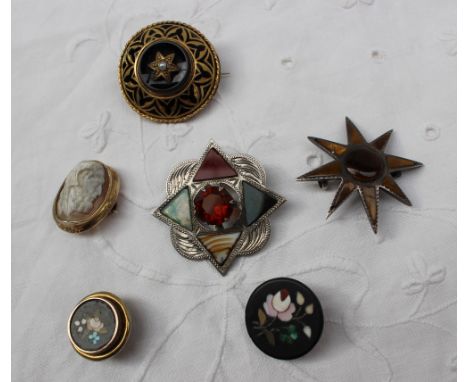 A Scottish silver hardstone set brooch together with a tigers eye brooch, a yellow metal and black enamel mourning brooch, tw