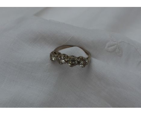 A four stone diamond ring set with four round brilliant cut diamonds in a line, each approximately 0.25 of a carat, to an 18c