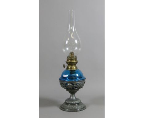 A Victorian oil lamp with pierced metal base, blue glass font and chimney.