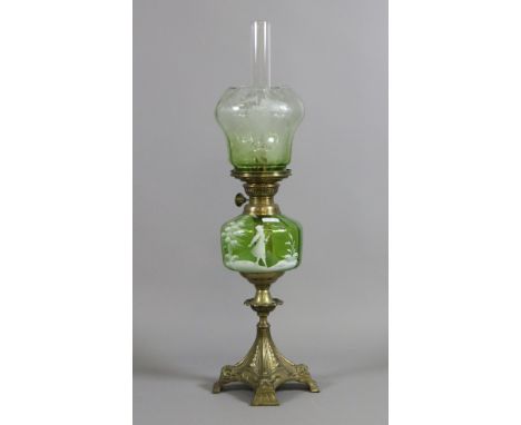 A Victorian ornate brass based oil lamp with Mary Gregory green glass font along with etched and coloured glass shade and chi