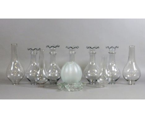 A collection of clear glass oil lamp chimneys.