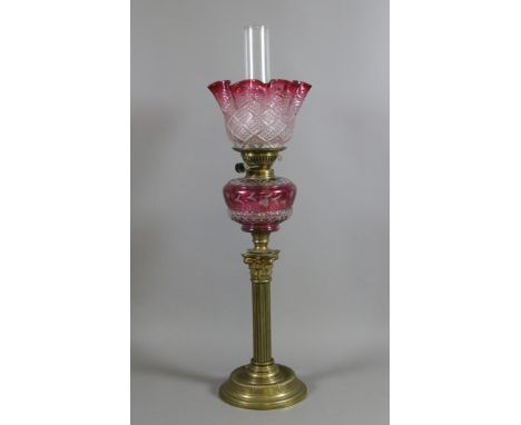A large Victorian brass Corinthian column oil lamp with coloured glass font and shade.